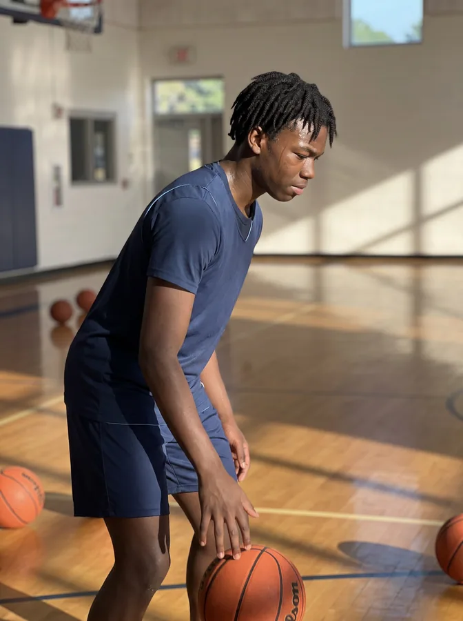 One of the phone photos a parent sent: a fictional basketball player at practice, dribbling in an empty gym; photo generated